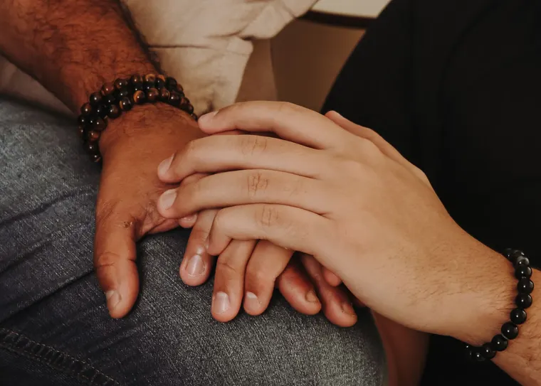 A hand held in two others, a gesture of comfort