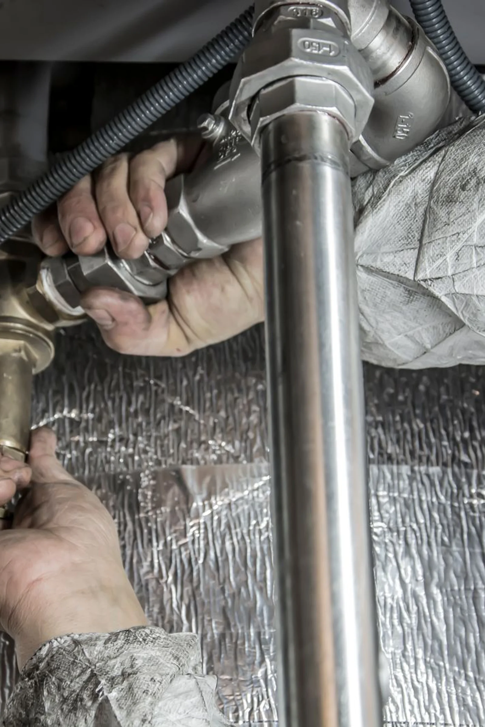 A plumber’s hands at work on a system