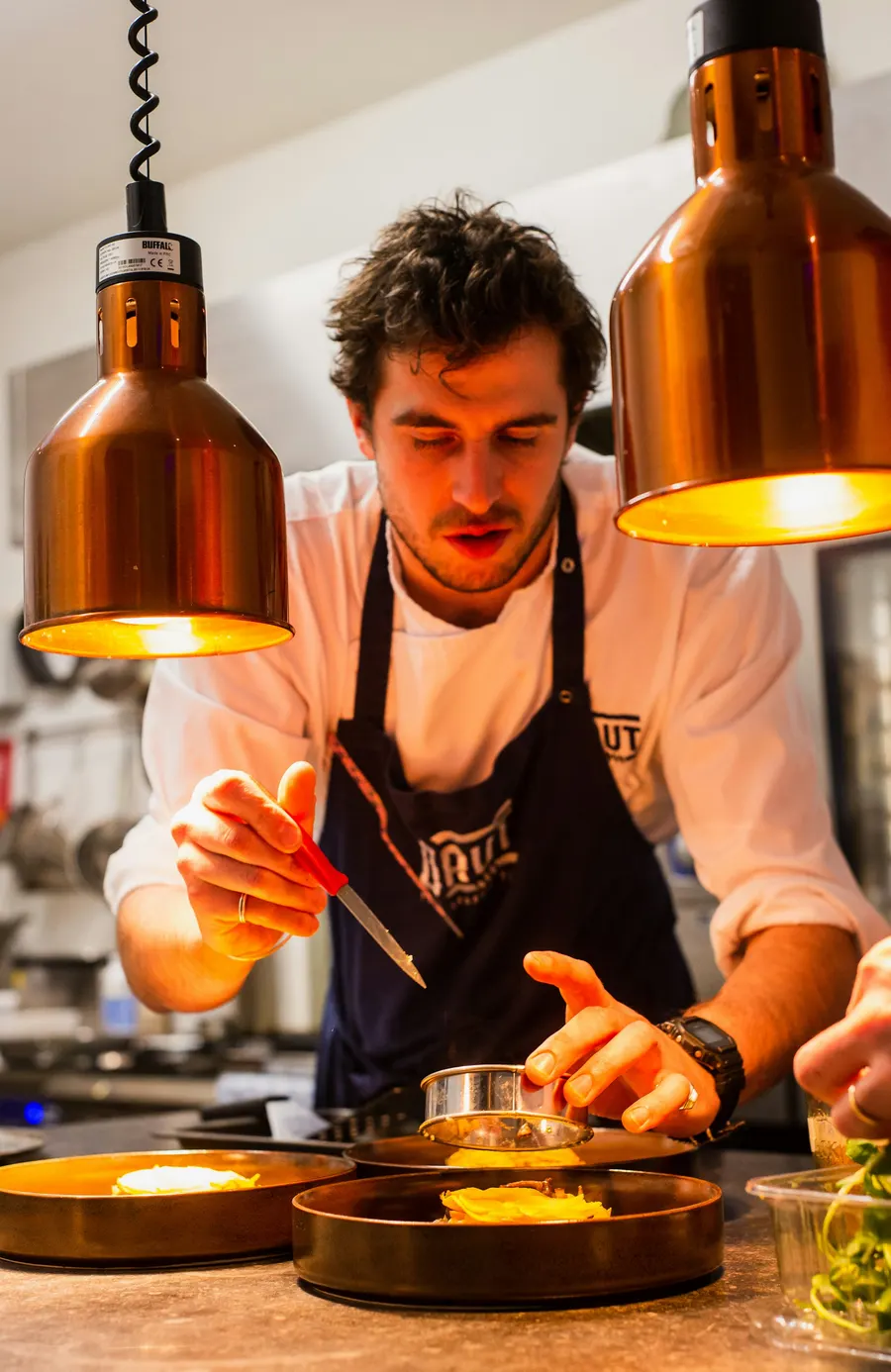 The pizzaiolo preparing a pizza by hand