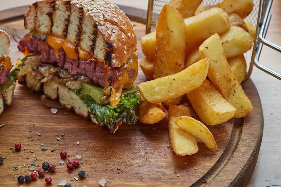 A cheeseburger with melted cheddar and caramelised onion