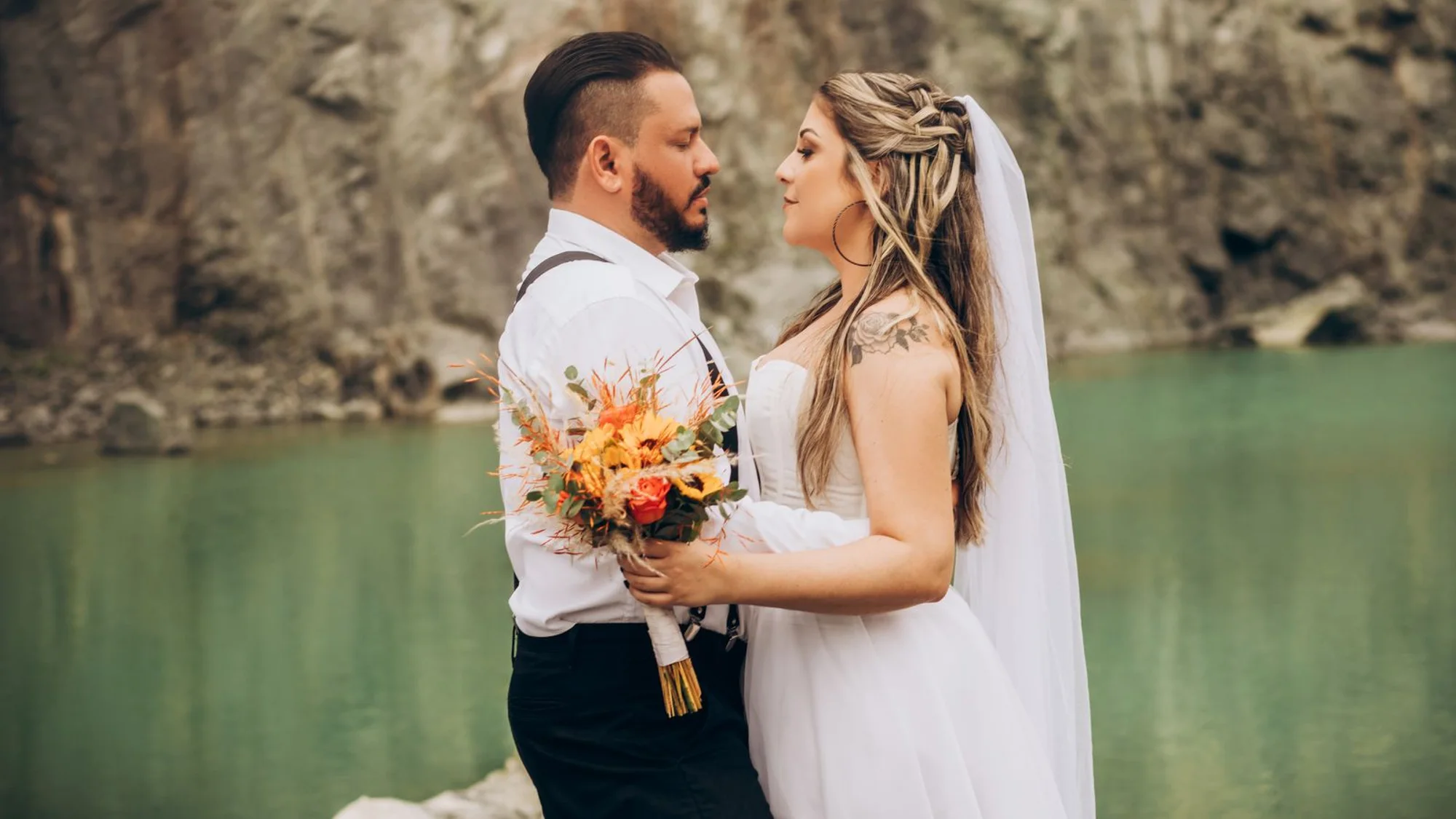 Newlyweds embracing by the lake at dusk